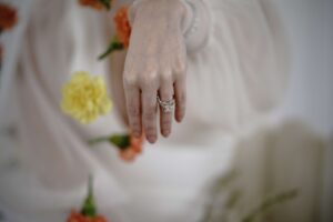 Bride holding a flower and showing her wedding ring