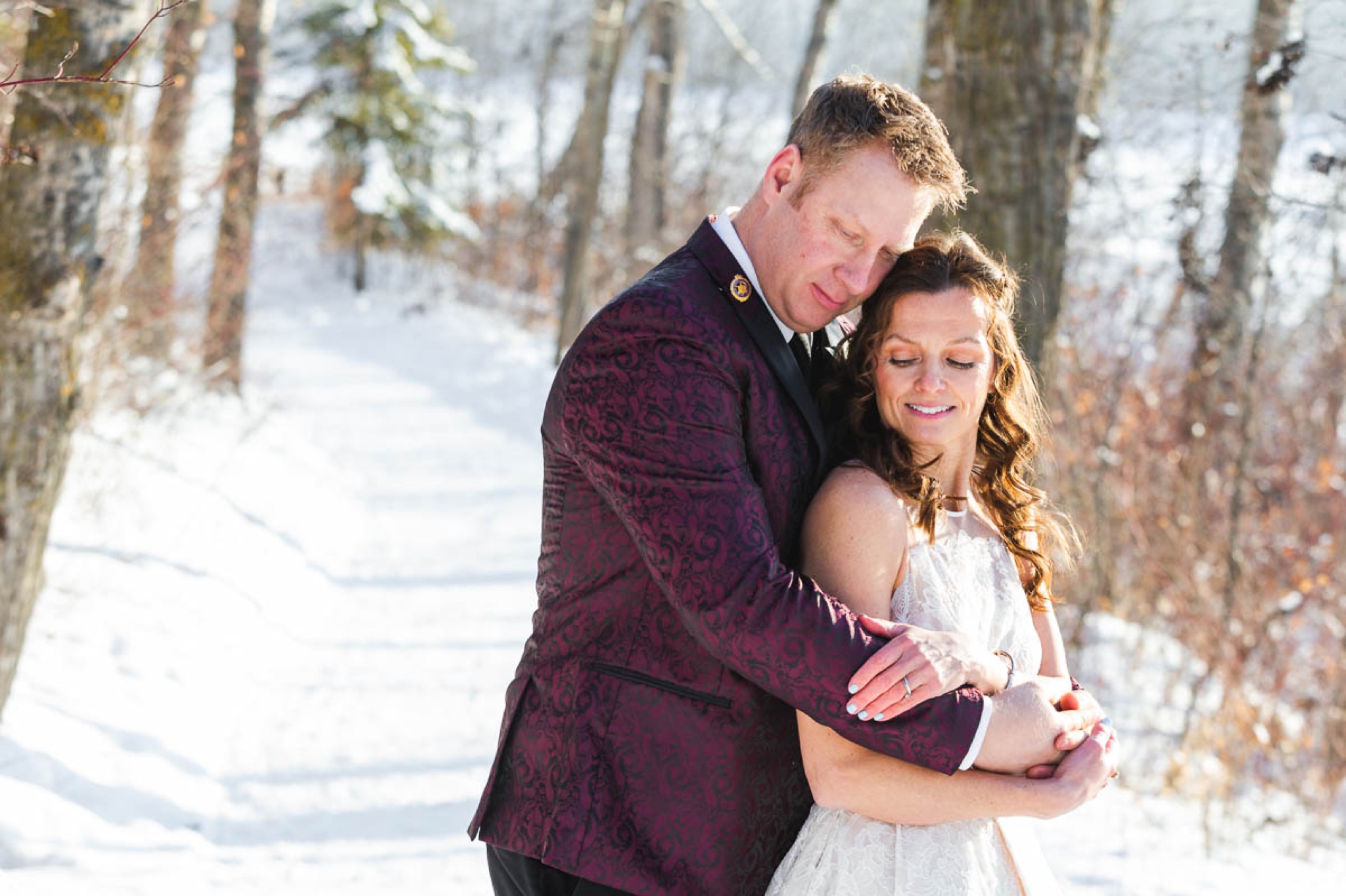 Wedding couple embracing for a photo with snowy landscape